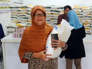 Warga mengambil beras bantuan sosial di Kantor Kelurahan Meruyung, Depok, Jawa Barat, Selasa (26/9/2023). Badan Pangan Nasional (Bapanas) menugaskan Perum Bulog membagikan Bantuan Sosial (Bansos) berupa beras kepada masyarakat berpendapatan rendah selama 3 bulan masing-masing 10 kg per keluarga penerima manfaat (KPM). (merdeka.com/Arie Basuki)