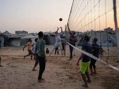 Anak-anak muda Palestina bermain voli di kamp tenda pengungsian di Zawayda, Jalur Gaza tengah, Selasa 4 November 2025. Beberapa anak muda Palestina bermain voli di kamp pengungsian Zawayda, Jalur Gaza tengah, pada Selasa 4 November 2025. (AP Photo/Abdel Kareem Hana)