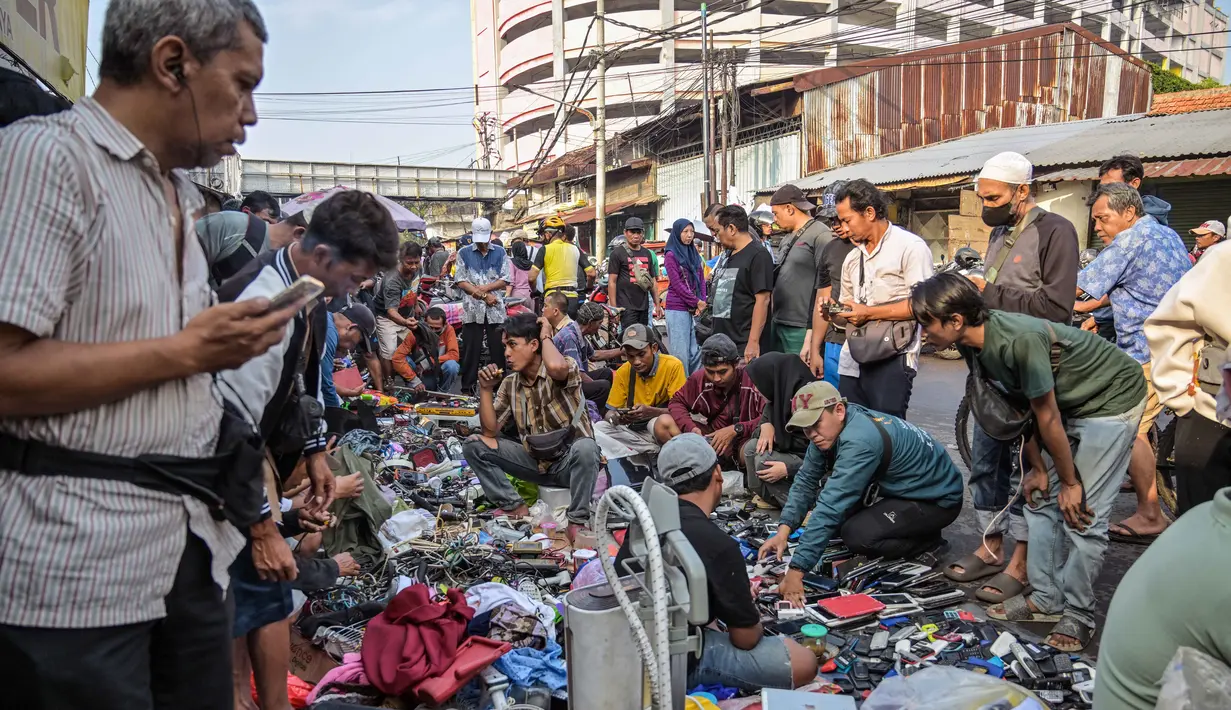 Sebagai informasi, cakupan Sensus Ekonomi 2026 adalah seluruh usaha ekonomi, termasuk usaha mikro/rumah tangga (pedagang pasar, warung, usaha online, industri tekstil, jasa, dll), kecuali sektor pertanian. Tampak dalam foto, orang-orang melihat-lihat barang bekas di salah satu ruas jalan, Surabaya, Jawa Timur, pada Minggu 19 April 2026. (JUNI KRISWANTO/AFP)