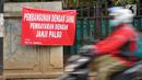 Pengendara motor melintas di depan poster protes warga terhadap pembangunan flyover di kawasan Tanjung Barat, Jakarta, Rabu (15/7/2020). Dalam poster protes tersebut, warga menuntut agar pembayaran pelunasan pembebasan lahan segera diselesaikan secara serentak. (Liputan6.com/Immanuel Antonius)