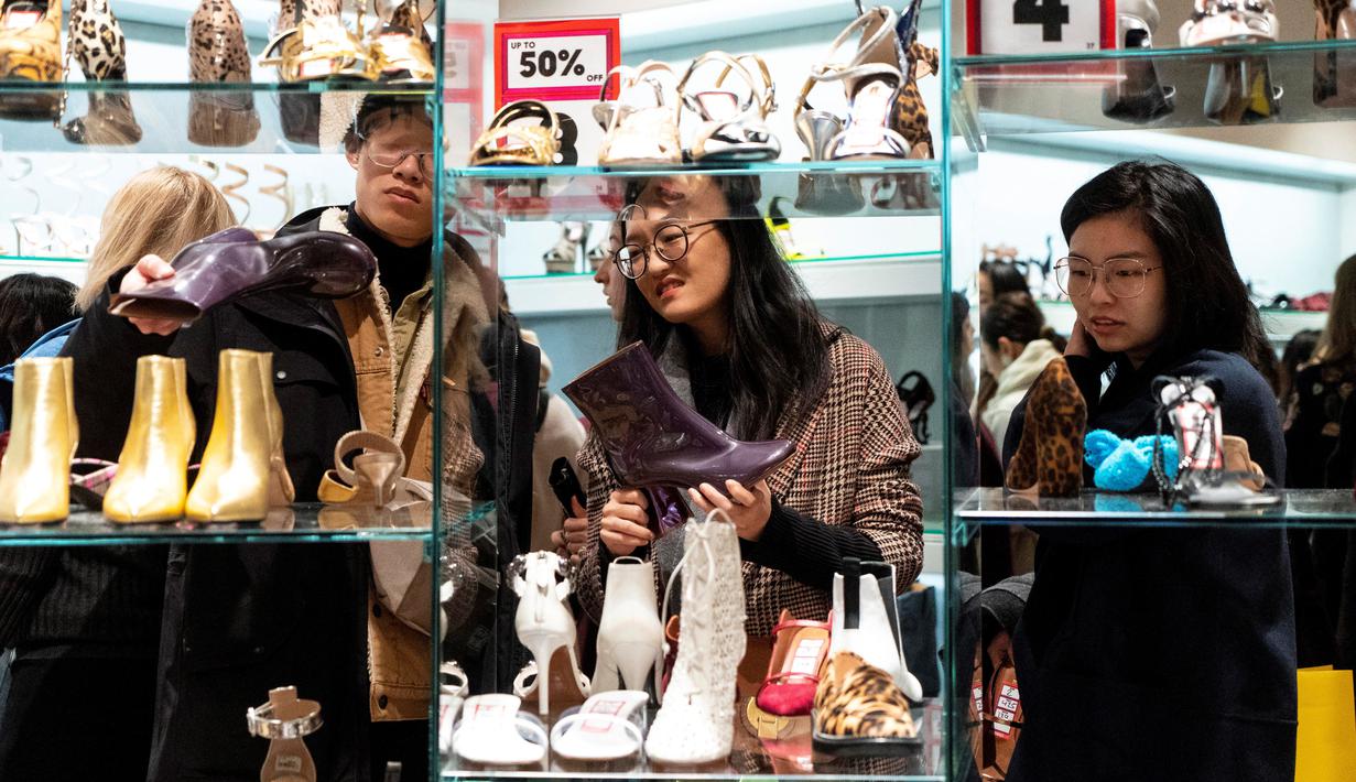 Pemburu diskon melihat sepatu selama Boxing Day di department store Selfridges, London, Kamis (26/12/2019). Boxing Day merupakan tradisi hari belanja terbesar tahunan yang diperingati setiap 26 Desember atau sehari setelah Natal dan menjadi hari libur nasional di Inggris. (Niklas HALLE'N/AFP)