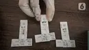 Petugas memperlihatkan hasil pemeriksaan tes cepat Antigen COVID-19 di GOR Kecamatan Makasar, Jakarta Timur, Senin (17/5/2021). Hari ini tercatat sebanyak 71 warga yang diundang oleh RT di wilayah masing-masing menjalani tes Covid-19, baik tes antigen maupun PCR. (merdeka.com/Iqbal S Nugroho)