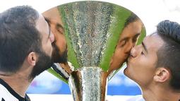 Dua striker Juventus, Gonzalo Higuain dan Paulo Dybala, mencium piala saat merayakan gelar Scudetto yang ke-33 usai mengalahkan Crotone pada laga Serie A di Stadion Juventus, Turin, Minggu (21/5/2017). (EPA/Alessandro Di Marco)