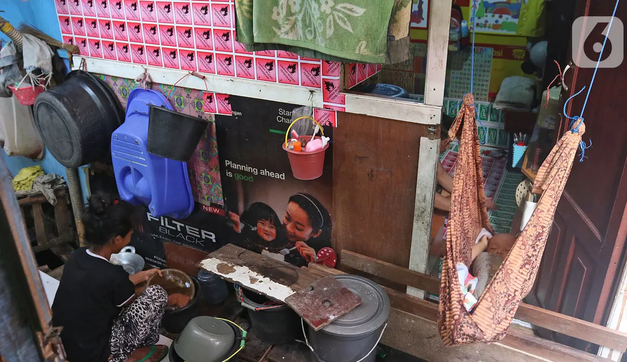 Warga mencuci peralatan rumah tangga saat seorang bayi tertidur dalam ayunan di Kampung Muka, Ancol, Jakarta, Selasa (5/11/2019). Pemprov DKI Jakarta mengusulkan anggaran konsultan penataan kampung kumuh sebesar Rp 556 juta per rukun warga (RW) pada rancangan APBD 2020. (Liputan6.com/HermanZakharia)