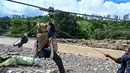 Keberadaan tali sling kini menjadi bagian penting dari kehidupan warga Kecamatan Ketol. Tampak dalam foto, warga menggunakan tali untuk menyeberangi sungai setelah banjir bandang yang menghancurkan desa-desa di sekitarnya di Ketol, provinsi Aceh, pada Selasa 6 Januari 2026. (CHAIDEER MAHYUDDIN/AFP)