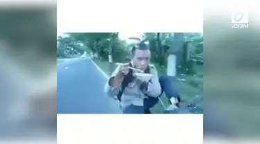 Seorang pria nekat kendarai motor sambil makan mie ayam. Ia melakukan aksinya hanya dengan satu kaki.