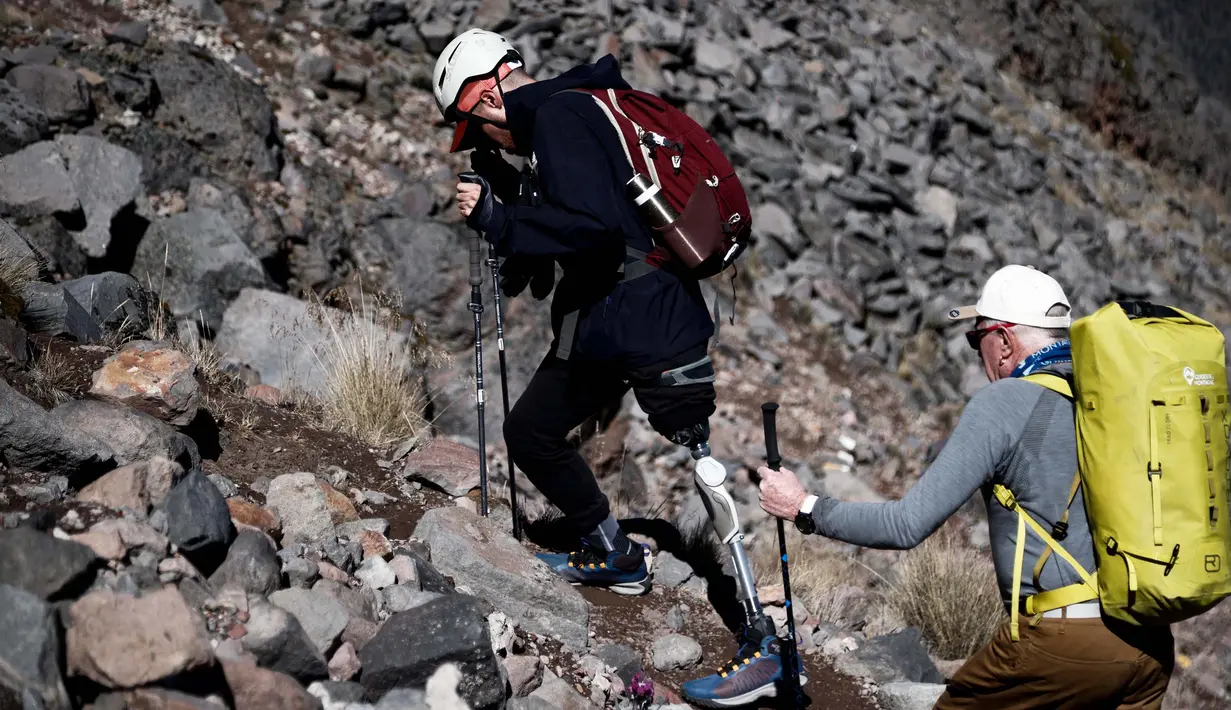 Penyintas kanker David Hernandez (kiri) saat mendaki gunung berapi Pico de Orizaba dalam sebuah ekspedisi di Puebla, Meksiko, pada tanggal 24 November 2023. (Rodrigo Oropeza/AFP)