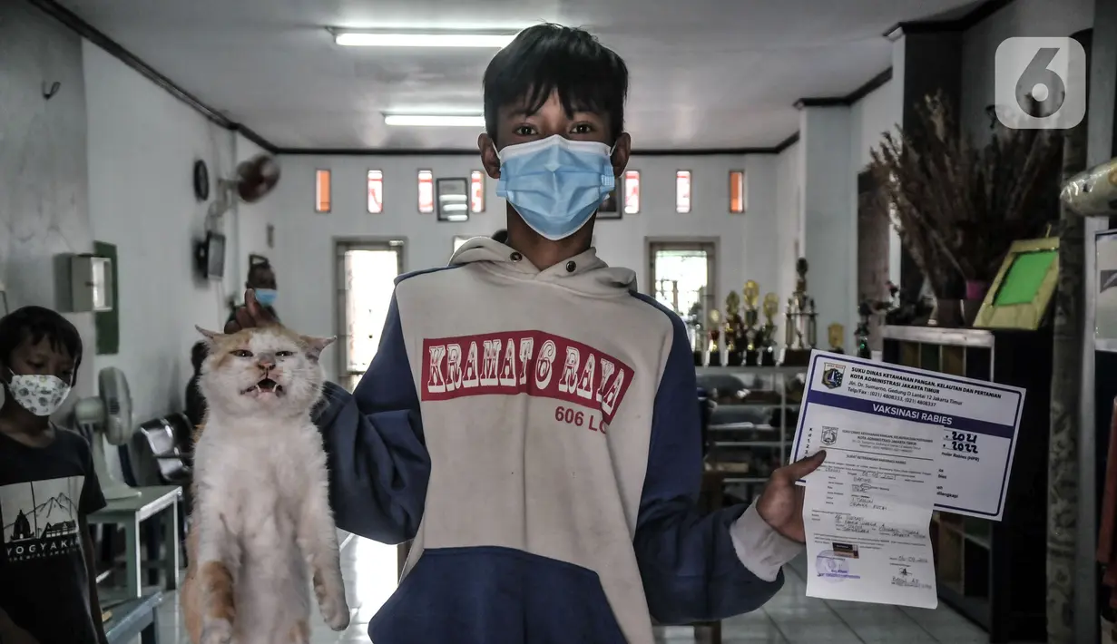 Warga menunjukkan sertifikat vaksinasi rabies hewan peliharaan di Kantor RW 07 Cipinang Muara, Jatinegara, Jakarta, Senin (6/9/2021). Vaksinasi keliling digelar di tiap RW hingga 15 September 2021. (merdeka.com/Iqbal S. Nugroho)