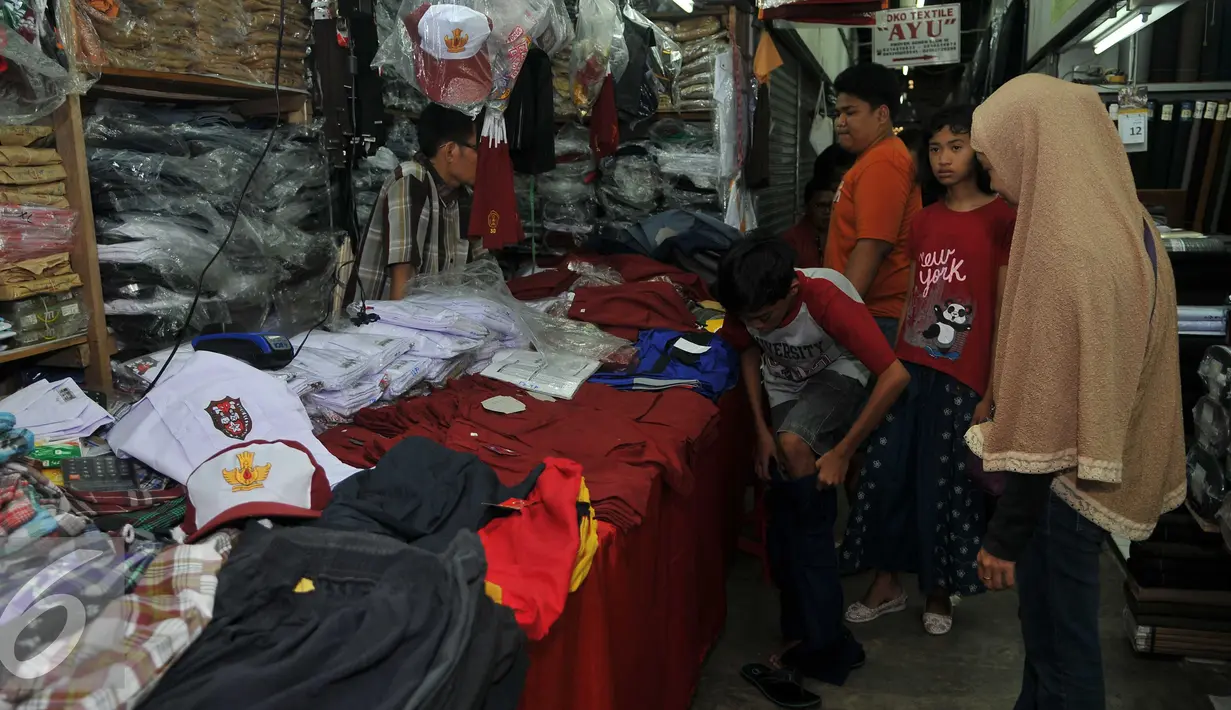 Seorang anak mencoba seragam di Pasar Senen, Jakarta, Selasa (12/7). Penjualan seragam sekolah menjelang tahun ajaran baru mengalami peningkatan sekitar 30-50 persen dari hari biasa. (Liputan6.com/Gempur m Surya)