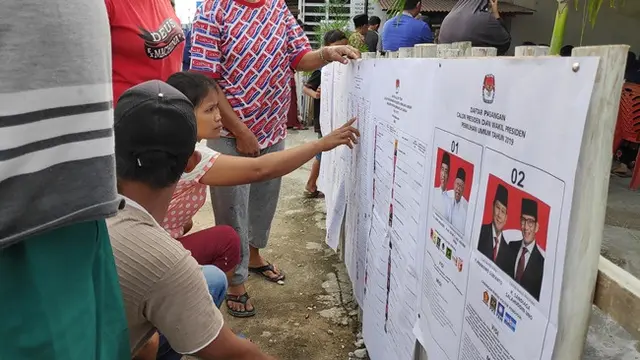 Sejumlah warga melihat contoh surat suara sebelum memantapkan pilihannya.