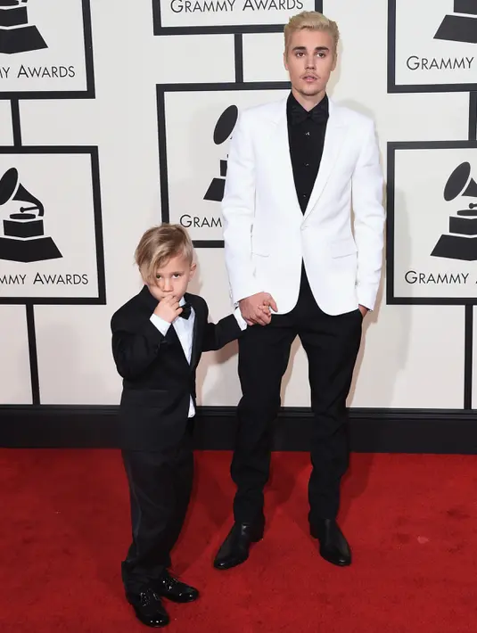 Justin Bieber dan adiknya, Jaxon, berpose di karpet merah Grammy Awards 2016 di Staples Center, Los Angeles, Senin (15/2). Penyanyi 21 tahun itu tampil kompak dengan sang adik yang juga mengenakan setelan jas. (Jason Merritt/Getty Images for NARAS/AFP)