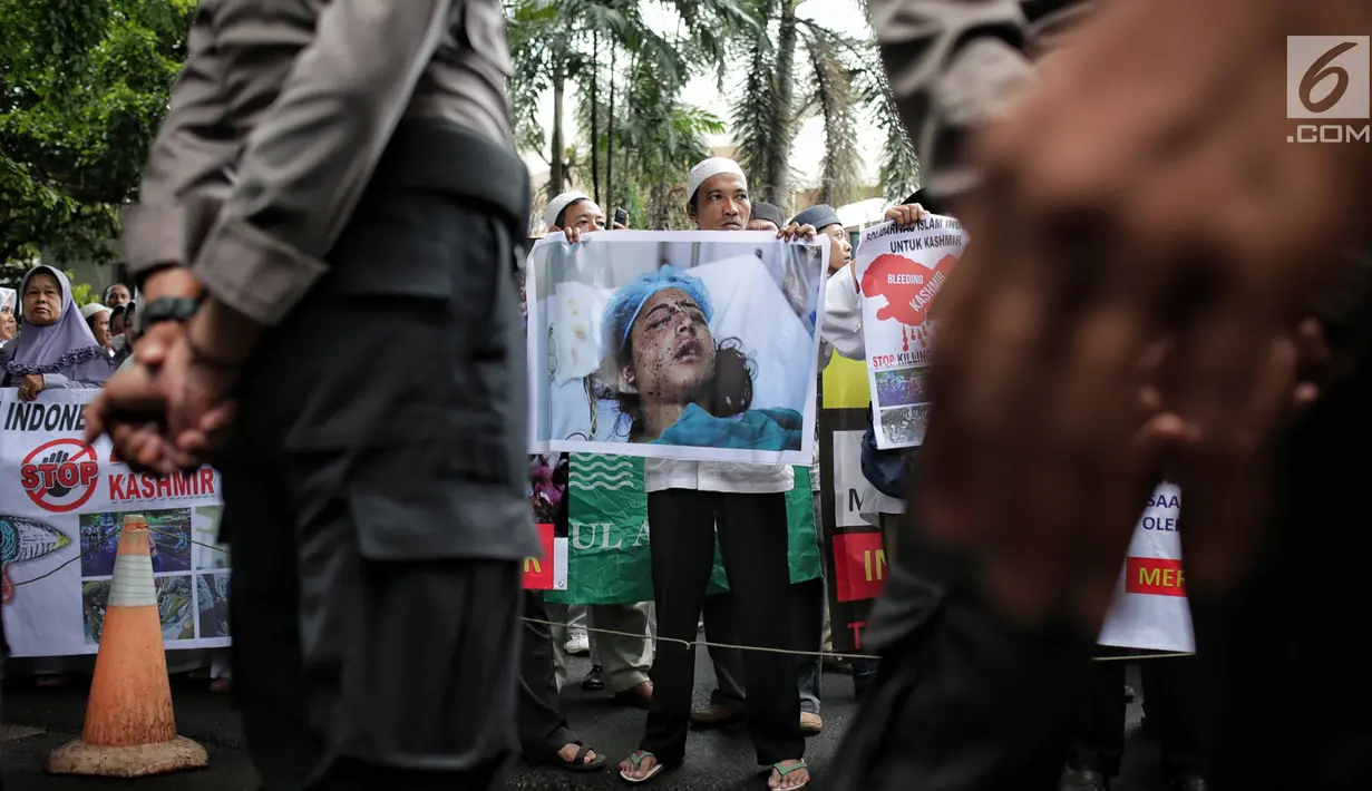 Massa membawa gambar warga Kashmr yang menjadi korban kekerasan dalam aksi solidaritas di depan Kedubes India, Jakarta, Rabu (6/2). Massa meminta pemerintah India segera menghentikan genosida yang dilakukan oleh militer. (Liputan6.com/Faizal Fanani)