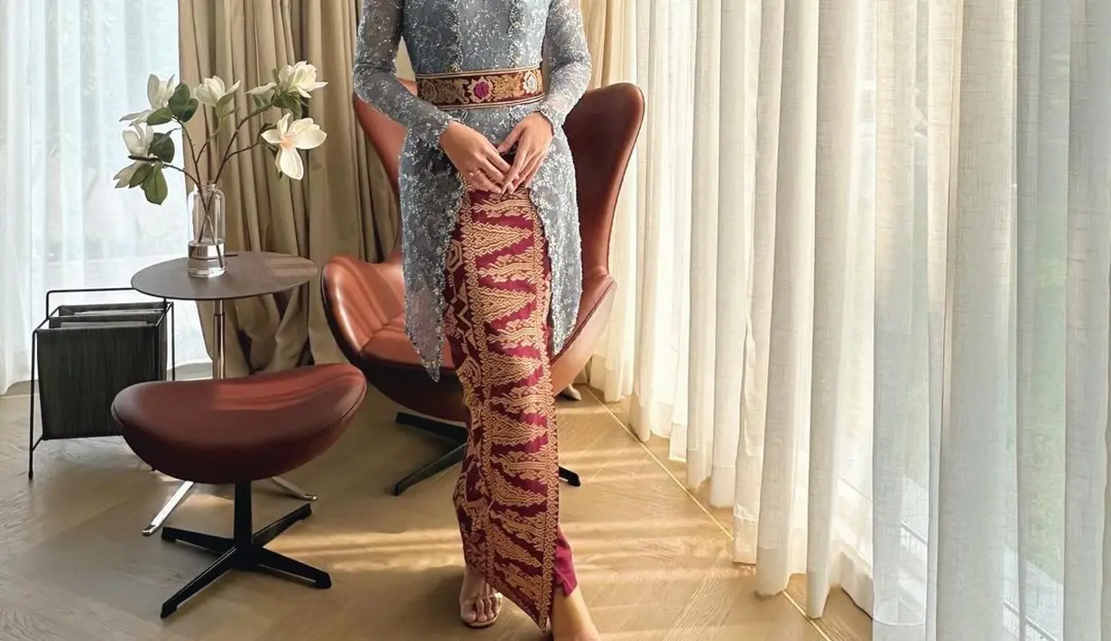 Raisa menawan dibalut kebaya brokat modern berwarna biru muda. Padu padan kain wastra merah sebagai rok dan belt yang diikatkan di pinggang menjadi aksen menarik yang menyempurnakan penampilan Raisa secara keseluruhan di sini. [Foto: Instagram/anjiasmara]