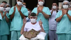 Veteran Perang Dunia II asal Brasil, Ermando Armelino Piveta meninggalkan Rumah Sakit Angkatan Bersenjata setelah pulih dari covid-19 di Brasilia, Selasa (14/4/2020). Kakek 99 tahun itu dipulangkan dari rumah sakit diiringi penghormatan militer dengan terompet dan tepuk tangan. (EVARISTO SA/AFP)