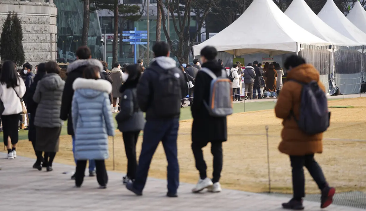 Orang-orang mengantre untuk tes virus corona COVID-19 sambil menjaga jarak sosial di klinik skrining sementara untuk virus corona dekat Balai Kota Seoul, Seoul, Korea Selatan, Rabu (26/1/2022). (AP Photo/Lee Jin-man)