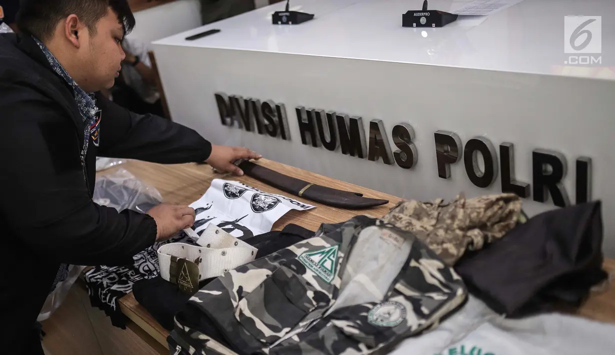 Petugas merapikan barang bukti kasus propaganda dan penyebaran hoaks SARA di Mabes Polri, Jakarta, Jumat (28/6/2019). Polisi menyita barang bukti laptop, hp, hardisk, dan atribut laskar FPI. (Liputan6.com/Faizal Fanani)