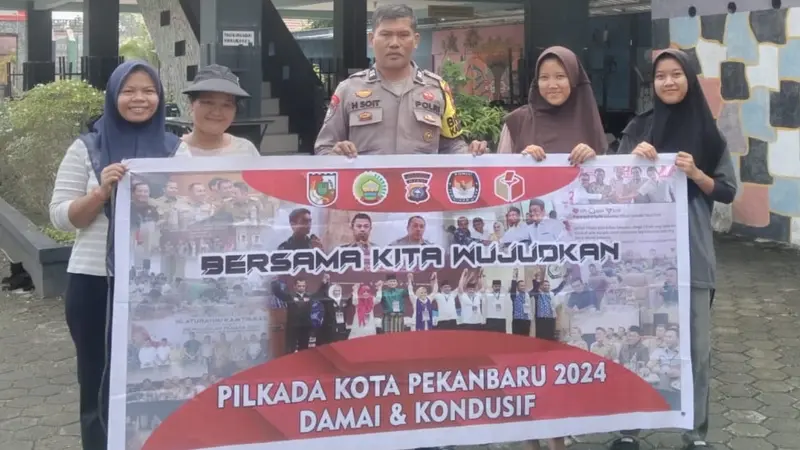 Personel Polresta Pekanbaru menyambangi masyarakat mengampanyekan Pilkada damai.