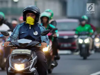 Pengendara sepeda motor mengenakan masker saat berkendara di Jakarta, Kamis (4/7/2019). Organisasi lingkungan Greenpeace menyatakan kualitas udara Jakarta saat ini terpantau sangat tidak sehat dengan angka 165 AQI atau Indeks Kualitas Udara. (merdeka.com/Imam Buhori)