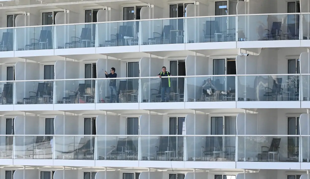 Penumpang dan awak terlihat pada kapal pesiar Spectrum of the Seas di Hong Kong, Rabu (5/1/2022). Spectrum of the Seas diperintahkan kembali ke kota untuk pengujian virus corona COVID-19 setelah sembilan orang ditemukan memiliki kontak dekat dengan varian Omicron baru-baru ini. (PETER PARKS/AFP)