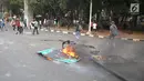 Rambu lalu lintas terbakar saat pelajar berdemonstrasi di belakang Gedung DPR, Palmerah, Jakarta, Rabu (25/9/2019). Selain membakar sejumlah benda, para pelajar juga melempari Gedung DPR dengan batu. (Liputan6.com/Angga Yuniar)