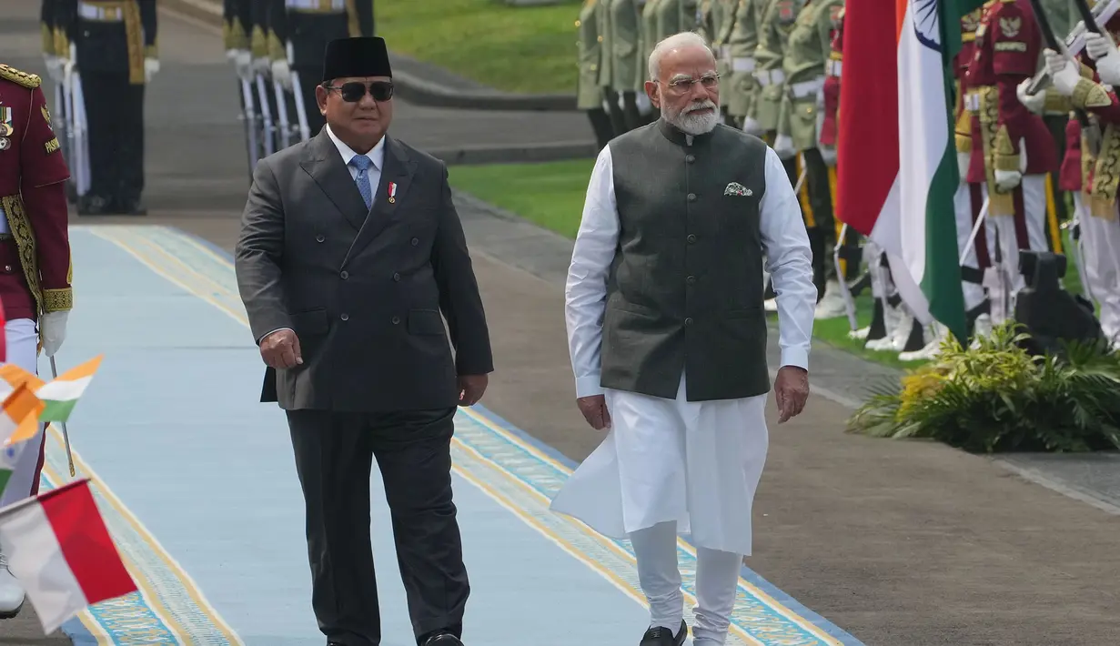 Presiden Prabowo Subianto bersama Perdana Menteri India Narendra Modi berjalan memeriksa pasukan di Istana Merdeka, Jakarta, Selasa, 7 Juli 2026. (AP Photo/Achmad Ibrahim)