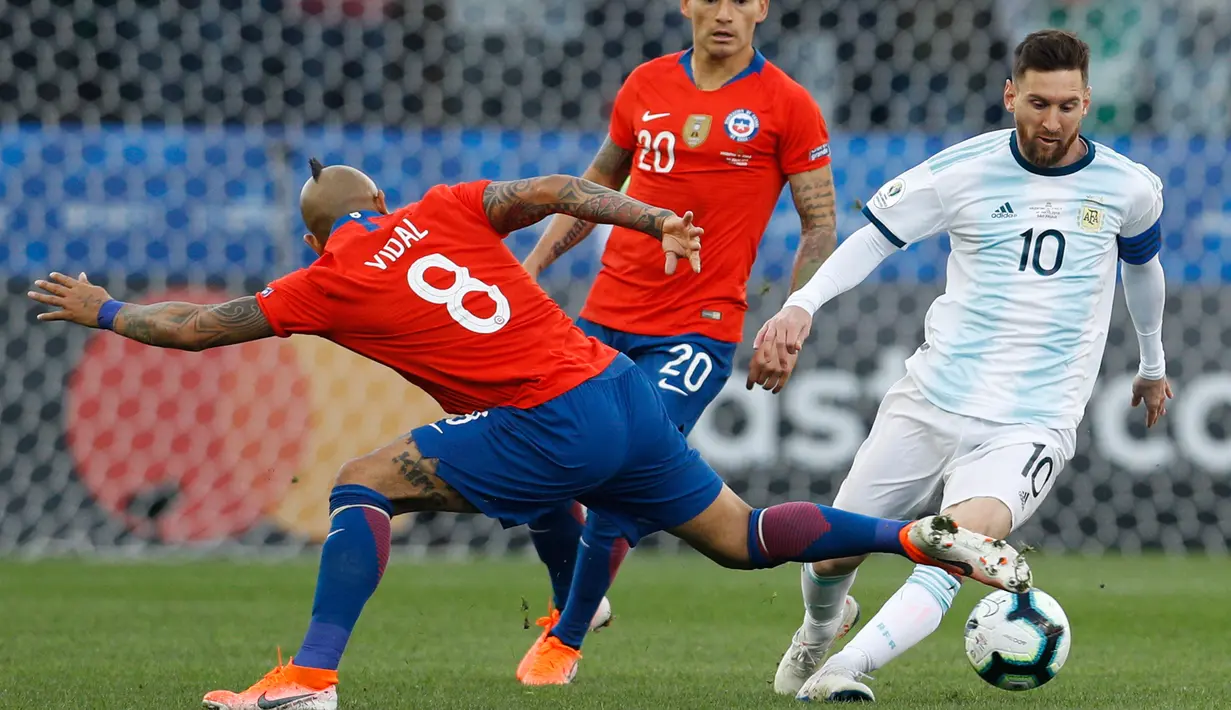 Penyerang Argentina, Lionel Messi berusaha melewati gelandang Chile, Arturo Vidal saat bertanding pada perebutan tempat ketiga Copa America 2019 di Arena Corinthians, Brasil (6/7/2019). Argentina sukses  merebut posisi ketiga usai mengalahkan Chile 2-1. (AP Foto/Victor R .Caivano)