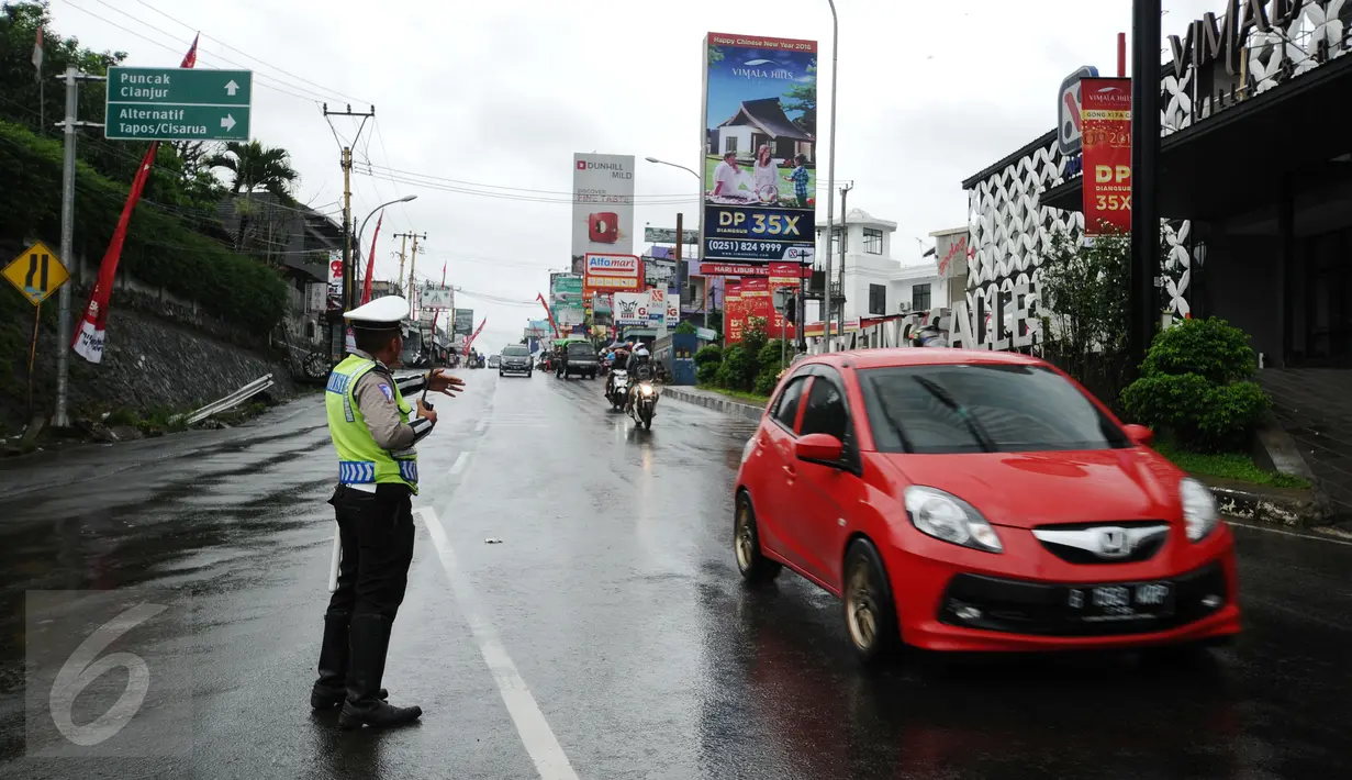 Petugas mengatur arus balik nenuju Jakarta jelang perempatan Gadog, Bogor, Senin (8/2/2016). Untuk mencegah kemacetan pasca libur panjang Tahun Baru Imlek 2016, Polres Bogor menerapkan buka tutup di jalur menuju puncak. (Liputan6.com/Helmi Fithriansyah)