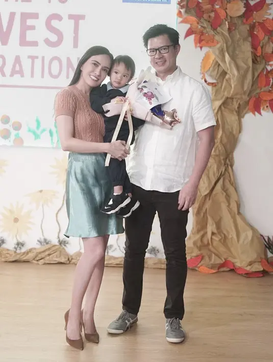 Bersama sang suami, Shandy pun tampil dengan atasan knit cokelat dipadukan skirt santin sage saat berkunjung ke sekolah anaknya.(@shandyaulia)