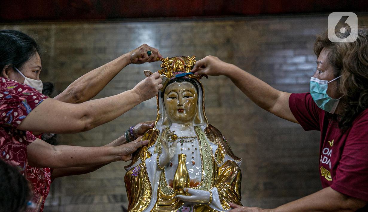 Para jemaat menyikat patung yang ada di Vihara Amurva Bhumi, Jakarta, Kamis (4/2/2021). Ritual mencuci patung dewa serta bersih-bersih ini dilakukan dalam rangka menyambut perayaan Tahun Baru Imlek 2572. (Liputan6.com/Faizal Fanani)