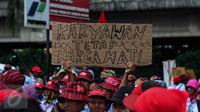 AMT (Awak Mobil Tangki) membawa poster saat melakukan mogok kerja dan unjuk rasa di Depot Pertamina Plumpang, Jakarta, Selasa (1/11). Mereka menuntut perusahaan menghapus sistem outsourcing dan membayar upah lembur mereka. (Liputan6.com/Faizal Fanani)