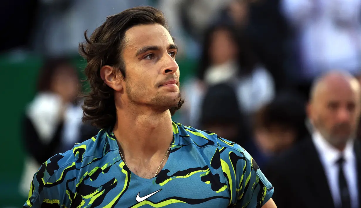 Ekspresi petenis Italia, Lorenzo Musetti setelah mengalahkan petenis Serbia, Novak Djokovic pada babak 16 besar Monte Carlo Open 2023 di Monte Carlo, Jumat (14/04/2023) dini hari WIB. Musetti menang dengan skor 4-6, 7-5, 6-4. (AFP/Valery Hache)