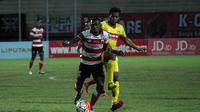 Pemain sayap Madura United, Engelberd Sani berduel dengan pemain tengah Bhayangkara FC, Zulfiandi di Stadion Gelora Delta, Sidoarjo, Minggu (22/10/2016). (Bola.com/Fahrizal Arnas)