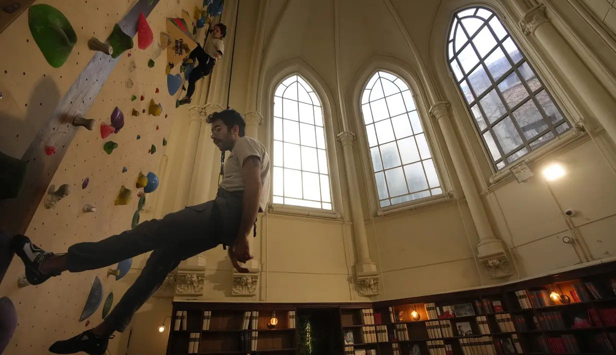 Peserta berlatih memanjat di lokasi Climbing District di Paris, Rabu, 11 Januari 2023. Tembok panjat buatan baru ini dibuka pada November 2022 di dalam bekas kapel abad ke-19, bernama le couvent des Oblats de Marie-Immaculee. (AP Photo/Christophe Ena)