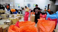 Petugas di Kantor Pos Pasar Baru memilah paket pos sesuai daerah tujuan yang akan dikirim, Jakarta, Selasa (1/7/14). (Liputan6.com/Faizal Fanani)