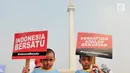 Dua anak kembar membawa poster saat mengikuti Festival Damai Millenial Road Safety di kawasan Monumen Nasional (Monas), Jakarta, Minggu (23/6). Festival ini juga dimeriahkan oleh berbagai atraksi dan pertunjukan musik artis Tanah Air. (merdeka.com/Iqbal Nugroho)