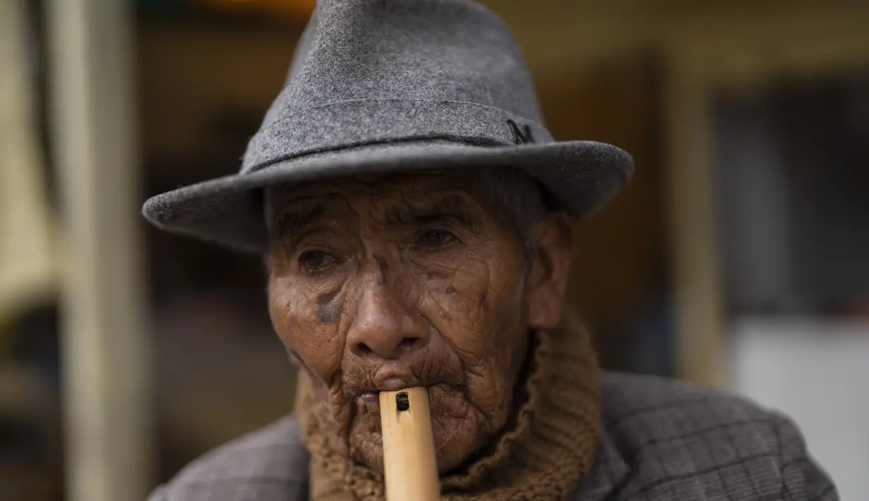Emegilo Toque, 95, memainkan serulingnya di pasar makanan populer di Puno, Peru, Minggu (29/1/2023). Tetapi gejolak politik yang berkepanjangan semakin mengancam untuk menggagalkan stabilitas ekonomi negara itu. (AP Photo/Rodrigo Abd)