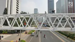 Pengendara melintas di bawah Jembatan Penyebrangan Orang (JPO) Dukuh Atas, Jakarta, Rabu (3/10). Rencananya Pemprov DKI Jakarta akan merelokasi JPO Dukuh Atas namun belum dapat dipastikan kapan dilaksanakan. (Liputan6.com/Herman Zakharia)