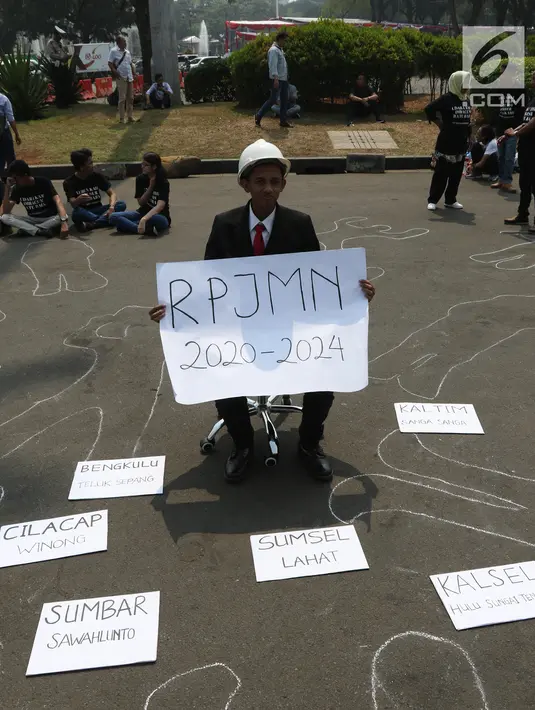 Aktivis menunjukkan pesan tuntutan saat menggelar aksi #BersihkanIndonesia di depan Istana Merdeka, Jakarta, Senin (19/8/2019). Aktivis menyerukan kebebasan hakiki dari kerusakan lingkungan dengan meninggalkan sumber energi fosil beralih ke energi bersih terbarukan. (Liputa6.com/Angga Yuniar)