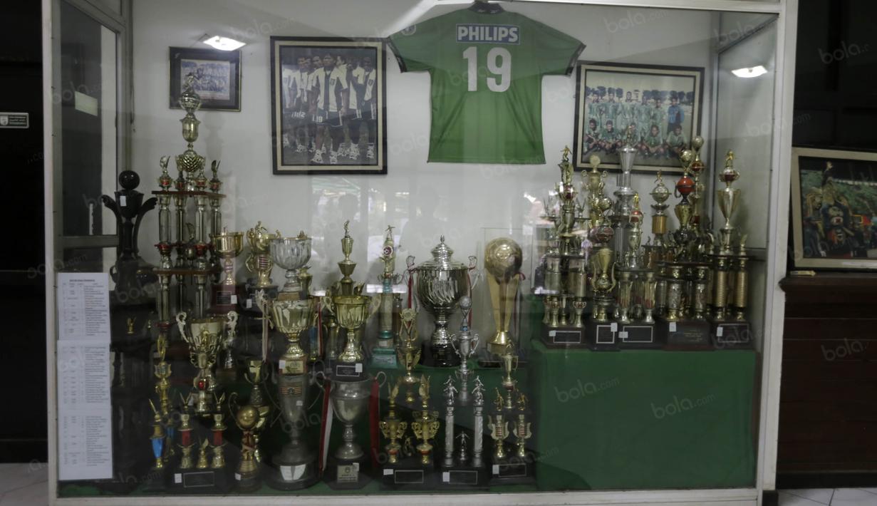 Berbagai tofi dan jersey legenda Persebaya dipajang dalam lemari kaca di Wisma Persebaya Karanggayam, Surabaya, Jumat(10/6/2016). (Bola.com/Nicklas Hanoatubun)