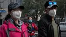 Sejumlah warga beraktivitas memakai masker pelindung untuk menghindari polusi udara buruk di Beijing, (22/10). (AFP Photo/Nicolas Asfaouri)