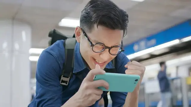 Seorang pria bermain game mobile