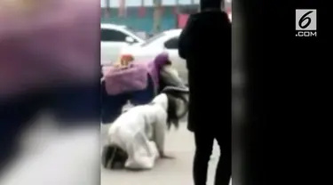 Seorang wanita merangkak pada sebuah jalanan ramai di China. Padahal sang pacar ada di sebelahnya sambil berjalan santai.