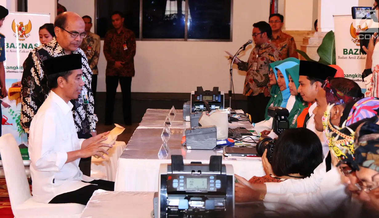 Presiden Joko Widodo menyiapkan uang yang akan dizakatkan melalui Badan Amil Zakat Nasional (Baznas) di Istana Negara, Jakarta, Rabu (14/6). Zakat tersebut diterima langsung oleh Ketua Baznas Bambang Sudibyo. (Liputan6.com/Angga Yuniar)