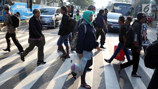 Warga melintasi Pelican Crossing di sekitar Halte Transjakarta Gelora Bung Karno, Jakarta, Jumat, (30/11). Ada tiga jembatan penyeberangan orang (JPO) di Jalan Jenderal Sudirman, Jakarta, yang sedang direvitalisasi. (Liputan6.com/Helmi Fithriansyah)