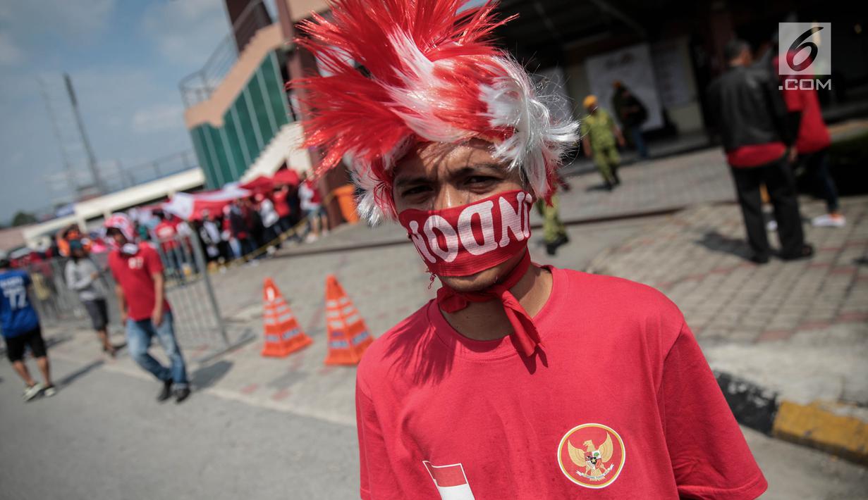 Suporter Garuda Muda menggunakan atribut merah putih untuk mendukung Timnas Indonesia U-22 melawan Timor Leste di Stadion Selayang, Selangor, Minggu (20/8). Indonesia melakoni laga ketiga dalam lanjutan grup B SEA Games 2017. (Liputan6.com/Faizal Fanani)