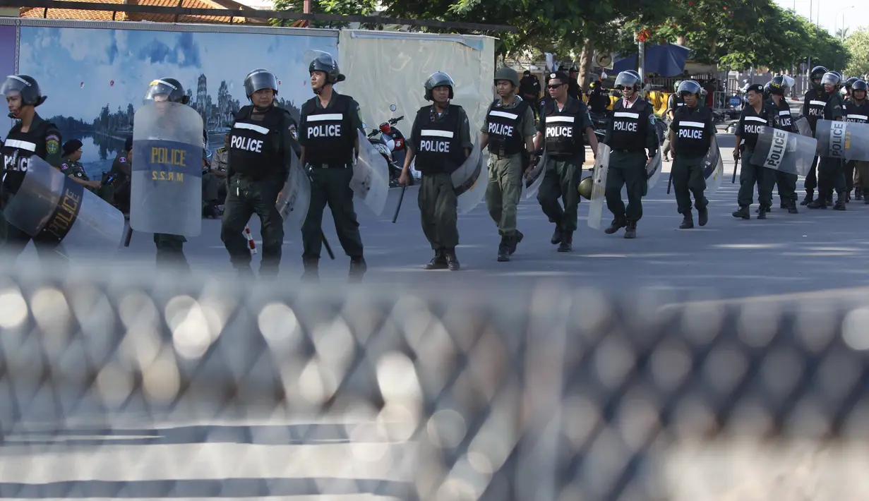 Petugas kepolisian memblokir jalan selama unjuk rasa berlangsung di Phnom Penh, Kamboja, Senin (13/7/2015). Pengunjuk rasa berpandangan aturan ini dapat memberangus pihak oposisi. (REUTERS/Samrang Pring)