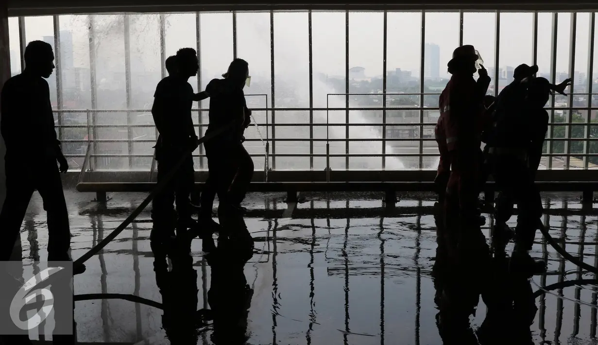 Petugas damkar memadamkan api saat silmulasi pemadaman api di lantai 5 di Senayan City, Jakarta, Kamis (26/11). Simulasi dilakukan untuk melatih kesiap-siagaan pengelola pusat belanja dalam menghadapi kebakaran. (Liputan6.com/Herman Zakharia)