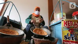 Pedagang membuat kerak telor di perkampungan Budaya Betawi, Setu Babakan, Jakarta, Sabtu (8/8/2020). Selama pandemi Covid-19 pedagang yang biasa mangkal di objek wisata tersebut sepi pembeli, namun mereka tetap bertahan untuk memenuhi kebutuhan hidup. (Liputan6.com/Fery Pradolo)