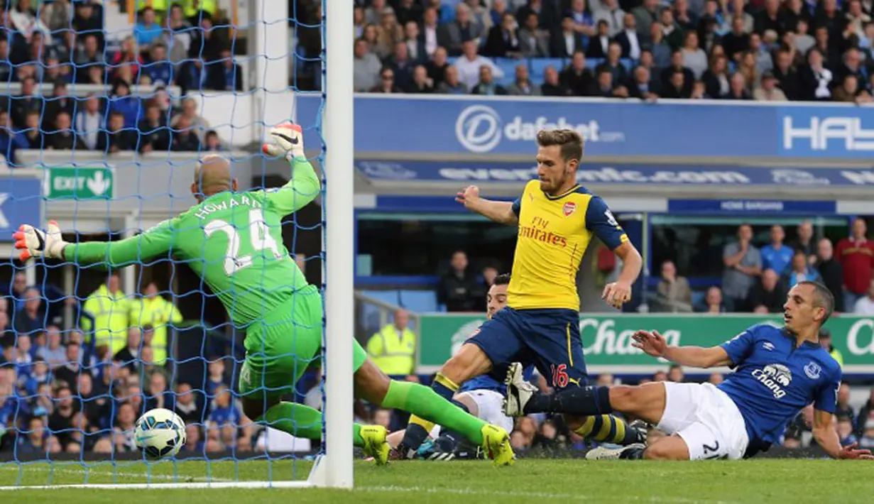 Gelandang Arsenal, Aaron Ramsey (tengah), berhasil mencetak gol ke gawang Everton saat berlaga di Stadion Goodison Park, (24/8/2014). (AFP PHOTO/Lindsey Parnaby)  