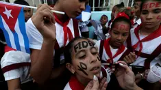 Sejumlah siswa melukis wajah mereka dengan tulisan Fidel saat menunggu mobil yang membawa abu mantan pemimpin Revolusi Kuba, Fidel Castro, lewat di Bayamo, Kuba (3/11). (Reuters/Enrique De La Osa)